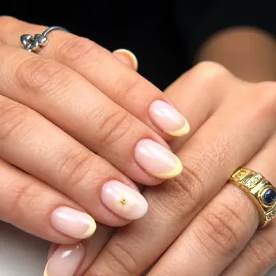 Manos con uñas naturales, punta clara y anillos dorados