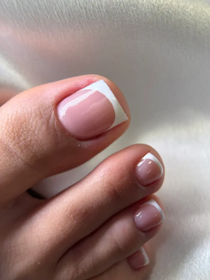 Pedicura con acabado francés sobre tela blanca